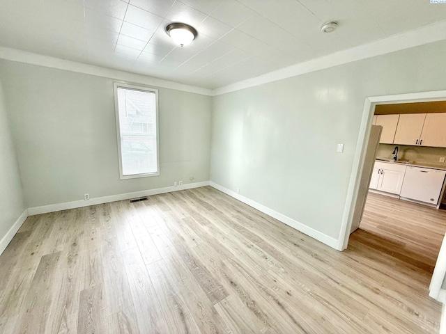 419 W A Ave, Colfax, WA 99111 - spare room featuring light wood-style floors, baseboards, ornamental molding, and a sink