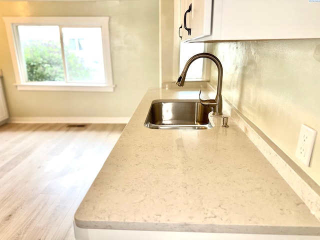 419 W A Ave, Colfax, WA 99111 - kitchen view of a sink, light wood-type flooring, light stone counters, white cabinets, and baseboards