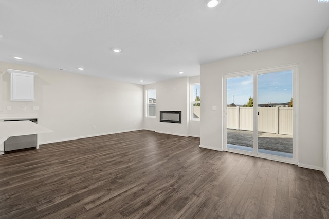 688 S Zeelar St, Kennewick, WA 99336 - unfurnished living room with dark wood-type flooring, a glass covered fireplace, baseboards, and recessed lighting