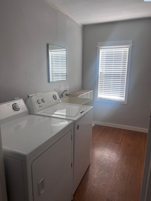 washroom with laundry area, dark wood-type flooring, a sink, baseboards, and independent washer and dryer