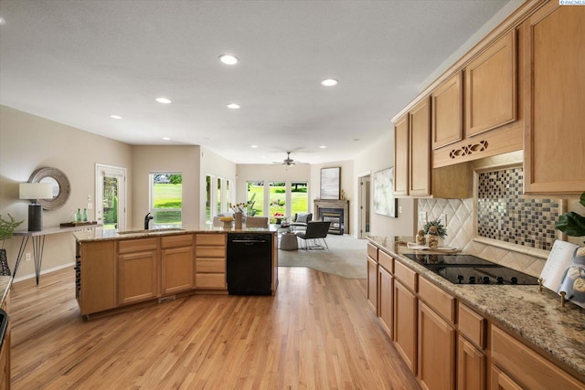 1209 W Canyon Lakes Dr, Kennewick, WA 99337 - kitchen featuring black appliances, light wood-type flooring, recessed lighting, a glass covered fireplace, and backsplash