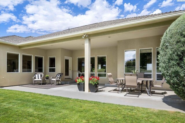 1209 W Canyon Lakes Dr, Kennewick, WA 99337 - back of property with a patio, stucco siding, and a yard