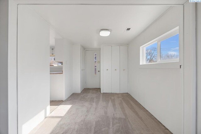 hallway featuring light colored carpet