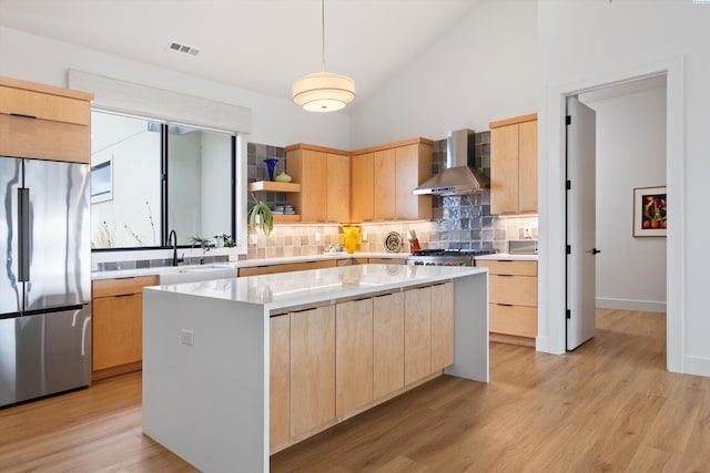 7004 Ricky Rd, Pasco, WA 93301 - kitchen with open shelves, light brown cabinetry, wall chimney exhaust hood, stainless steel fridge, and a center island