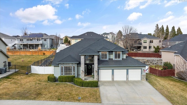 view of front of home with roof with shingles, a front yard, fence, a residential view, and driveway