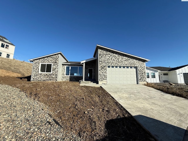 view of front of house with stone siding, concrete driveway, and an attached garage