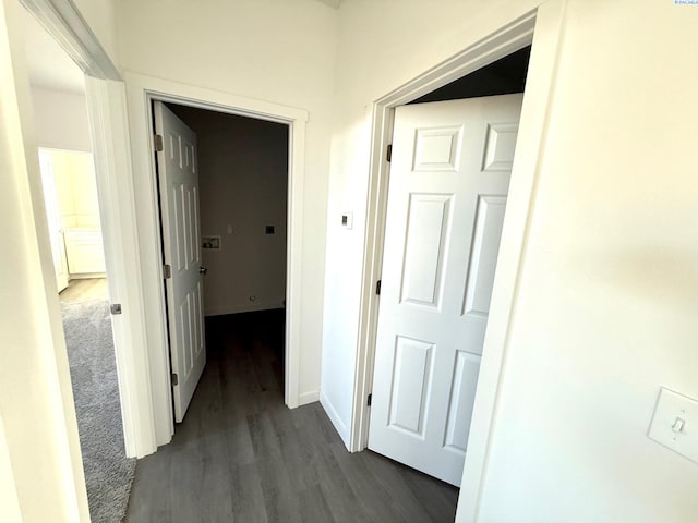 corridor with baseboards and dark wood finished floors