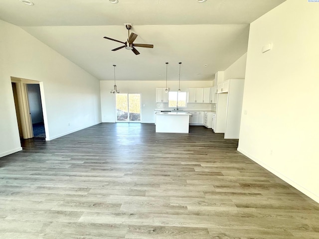 unfurnished living room featuring high vaulted ceiling, light wood-type flooring, a ceiling fan, and baseboards