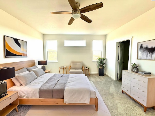 bedroom with light tile patterned floors, baseboards, and a ceiling fan