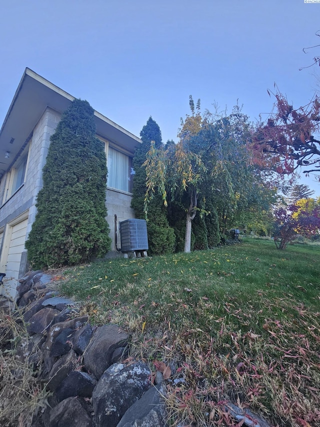 view of home's exterior featuring a lawn and central air condition unit