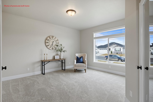 living area with light colored carpet and baseboards