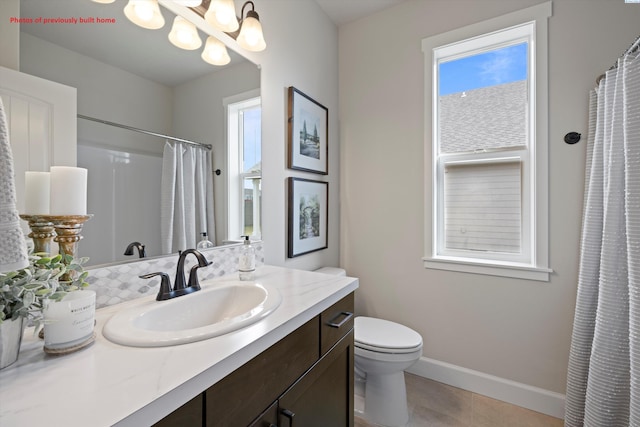 full bathroom featuring a notable chandelier, a shower with shower curtain, vanity, baseboards, and tile patterned floors