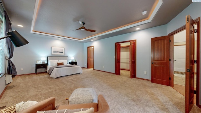 bedroom featuring a tray ceiling, light carpet, baseboards, recessed lighting, and ceiling fan
