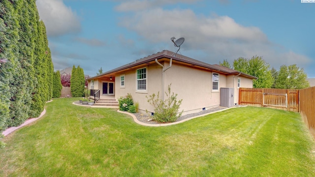 rear view of house featuring stucco siding and a gate