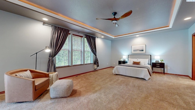 carpeted bedroom with a raised ceiling, baseboards, recessed lighting, and ceiling fan