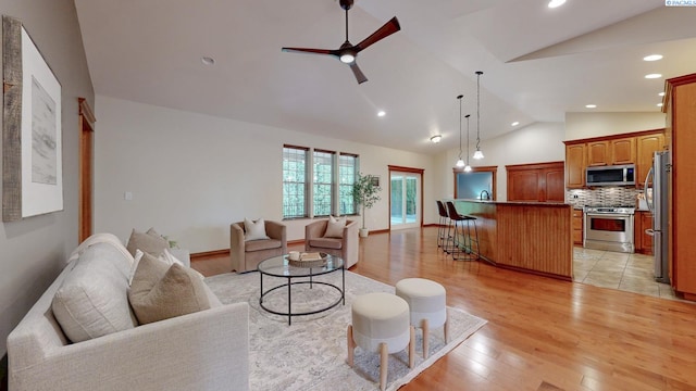 living room featuring lofted ceiling, a ceiling fan, light wood finished floors, and recessed lighting