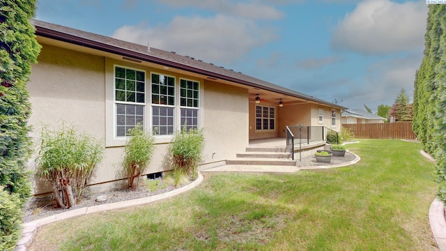 rear view of house with stucco siding and ceiling fan