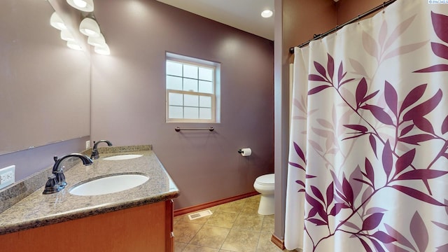 full bath featuring toilet, baseboards, double vanity, and tile patterned floors