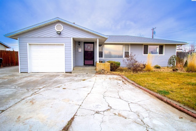 ranch-style home with a garage and a front lawn