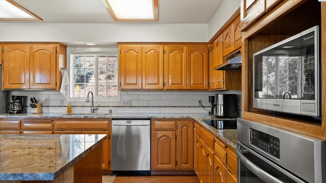 151002 W Richards Rd, Prosser, WA 99350 - kitchen with stainless steel appliances, under cabinet range hood, light stone countertops, backsplash, and recessed lighting