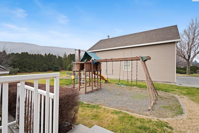 view of jungle gym with a mountain view and a yard