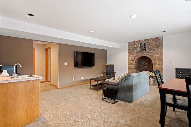 carpeted living room featuring sink and a fireplace