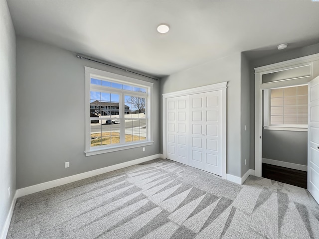 unfurnished bedroom with carpet floors, a closet, and baseboards