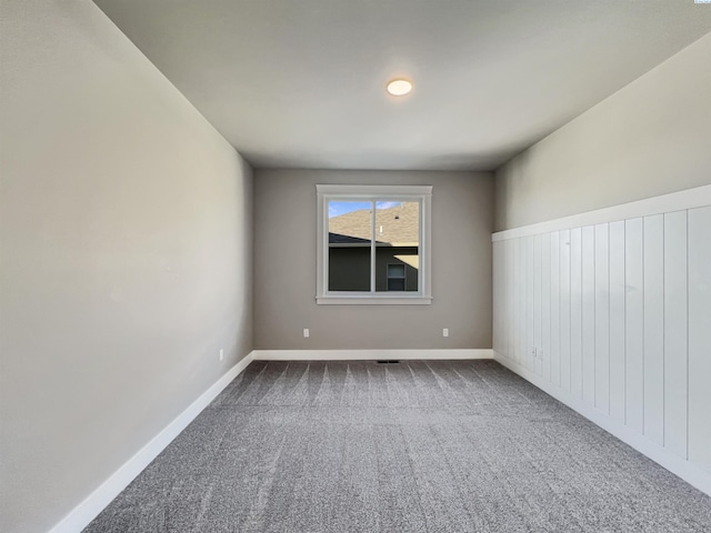 carpeted empty room featuring baseboards