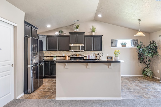 3313 Aqueduct Ln, Pasco, WA 99301 - kitchen featuring stainless steel appliances, vaulted ceiling, dark countertops, a breakfast bar area, and a textured ceiling