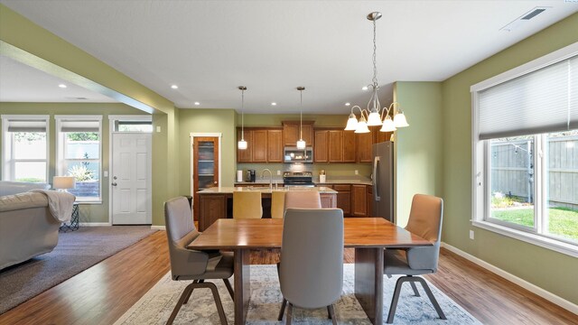 6102 Westmoreland Ln, Pasco, WA 99301 - dining room with wood finished floors, a chandelier, and recessed lighting