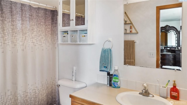 235 E Lilac Pl, Othello, WA 99344 - full bathroom featuring toilet, vanity, a shower with shower curtain, and backsplash