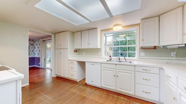 kitchen featuring white cabinets, light wood-style floors, a sink, and dishwasher