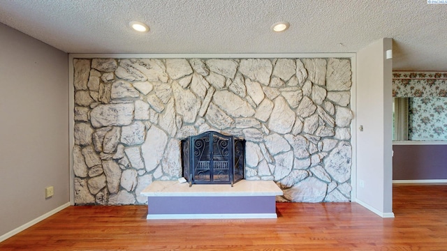 room details with baseboards, a textured ceiling, and wood finished floors