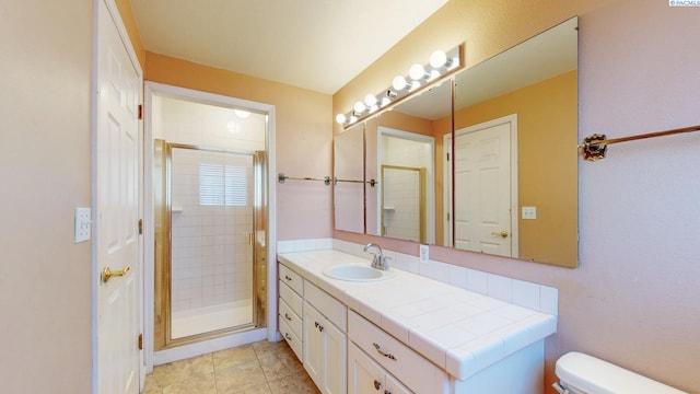 bathroom with toilet, tile patterned floors, a shower stall, and vanity
