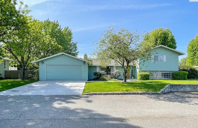 view of front of property featuring concrete driveway, a front yard, and a garage