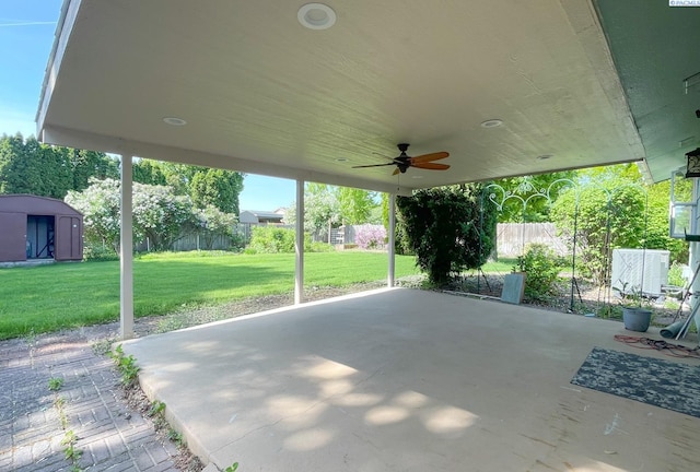 view of patio featuring a ceiling fan, a shed, an outbuilding, and fence