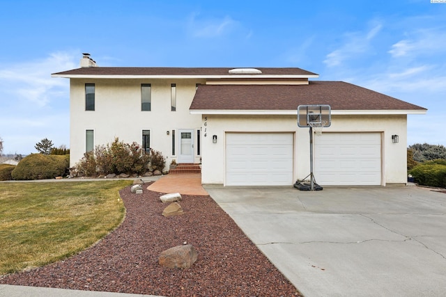 view of property with a garage and a front lawn