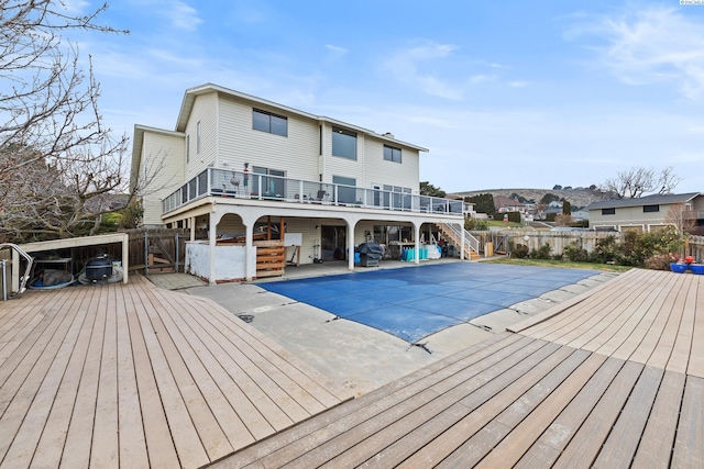 back of house with a swimming pool side deck and a patio area