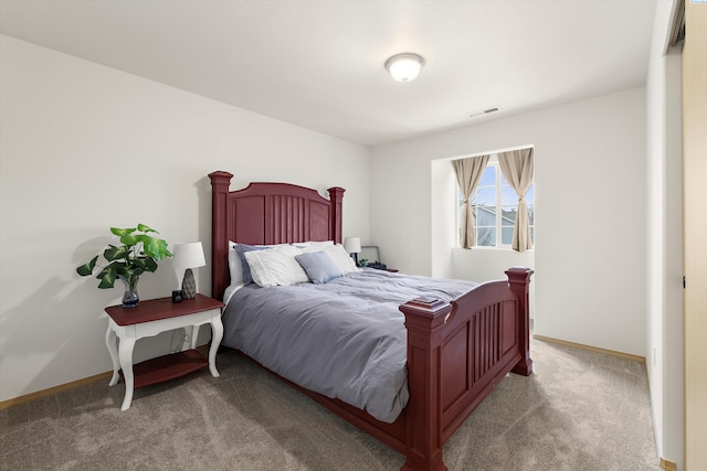 bedroom with baseboards and light colored carpet