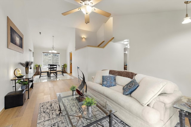 living room featuring light wood-style floors, high vaulted ceiling, and a ceiling fan