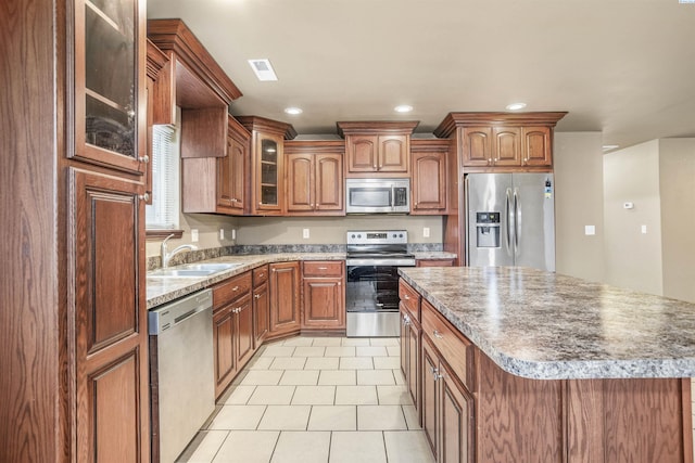 1408 Singh Ln, Sunnyside, WA 98944 - kitchen with stainless steel appliances, a center island, sink, and light tile patterned floors