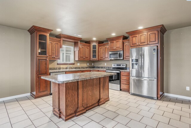 1408 Singh Ln, Sunnyside, WA 98944 - kitchen featuring light tile patterned floors, sink, stainless steel appliances, and a center island