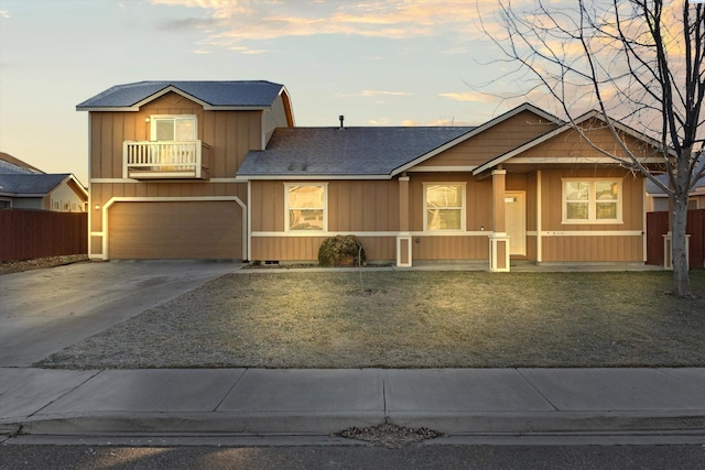 view of front of home with a balcony, a garage, and a yard