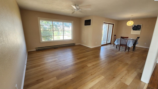 dining space featuring ceiling fan, light wood-type flooring, and baseboard heating