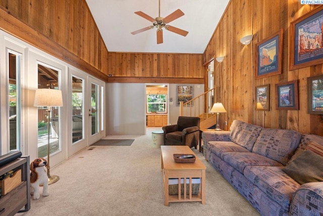 835 SE Spring St, Pullman, WA 99163 - carpeted living area featuring wood walls, high vaulted ceiling, a ceiling fan, and stairs