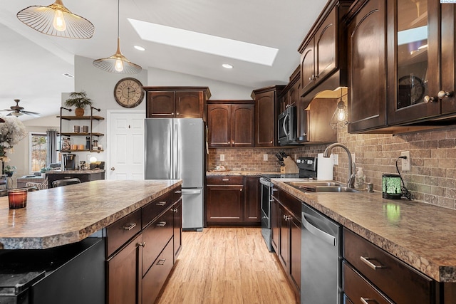 5504 Koufax Ln, Pasco, WA 99301 - kitchen featuring stainless steel appliances, vaulted ceiling, a skylight, a sink, and dark countertops