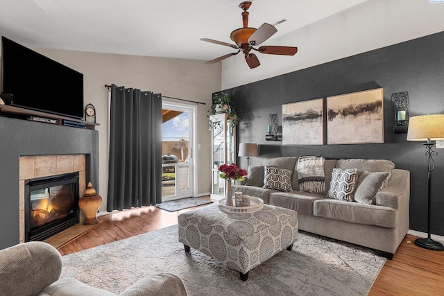 5504 Koufax Ln, Pasco, WA 99301 - living area with ceiling fan, wood finished floors, a tiled fireplace, baseboards, and vaulted ceiling