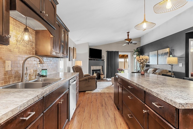 5504 Koufax Ln, Pasco, WA 99301 - kitchen with a sink, open floor plan, vaulted ceiling, a tiled fireplace, and light wood finished floors