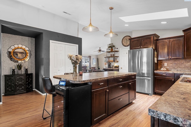 5504 Koufax Ln, Pasco, WA 99301 - kitchen with freestanding refrigerator, a skylight, a kitchen island, light wood-style flooring, and tasteful backsplash