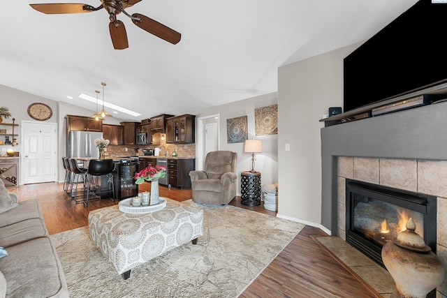 5504 Koufax Ln, Pasco, WA 99301 - living room with vaulted ceiling, a ceiling fan, a fireplace, and wood finished floors